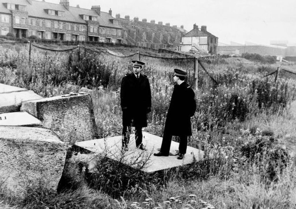 Two officers standing in the location where Brian Howe's body was discovered